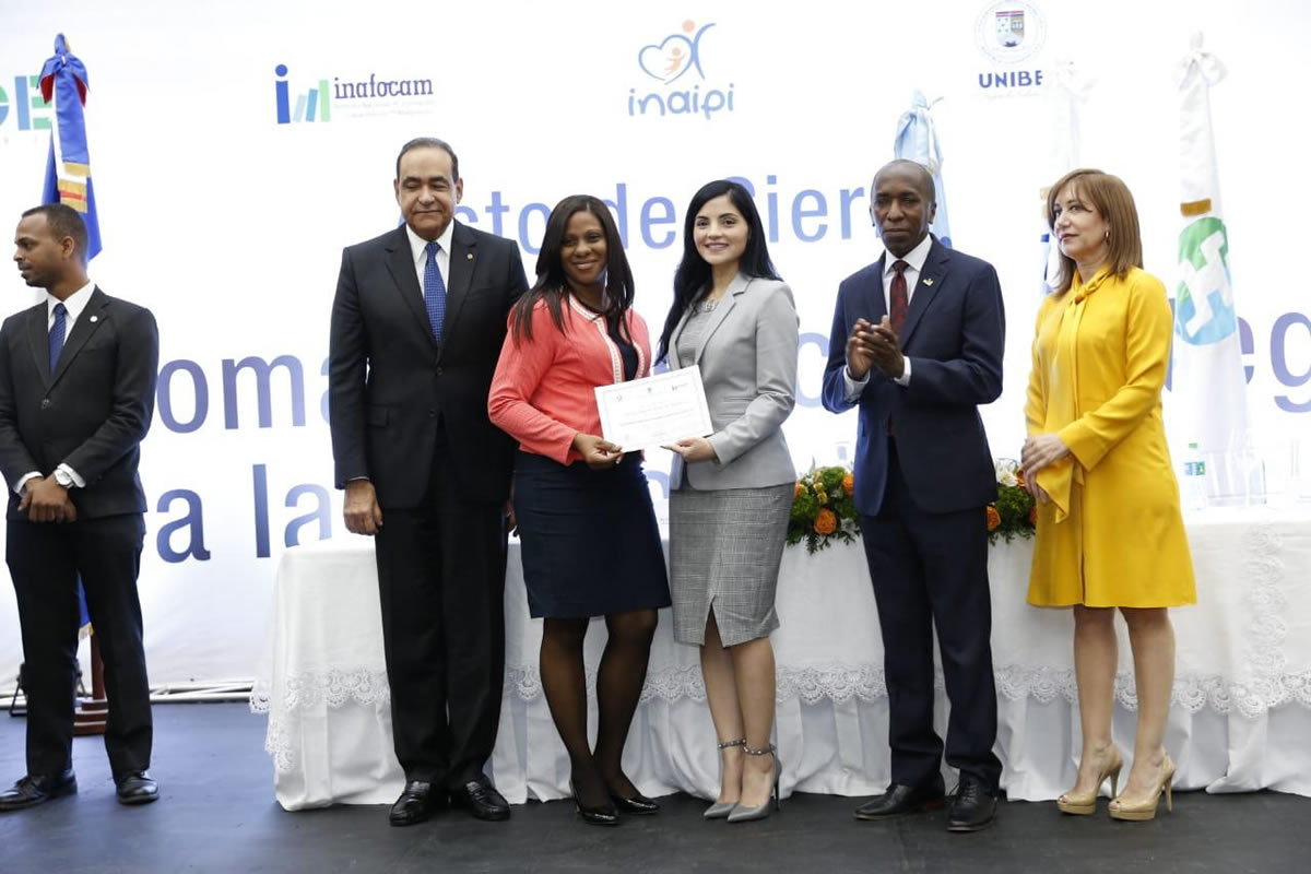 Rector de UNIBE, Directores del INAIPI e INAFOCAM y la Representante de la OEI en la RD, entregando certificados a los egresados del Diplomado